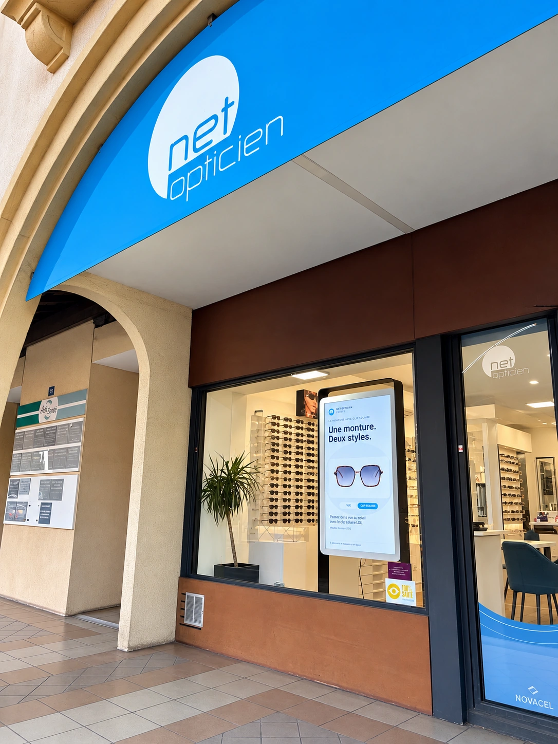 Devanture de Net Opticien à Lattes, sous les arcades, avec son enseigne bleue